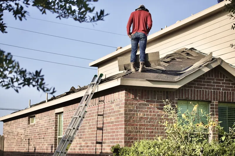 Professional roofer working on a residential roof in Greenock